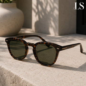 Tortoiseshell sunglasses resting on a stone ledge